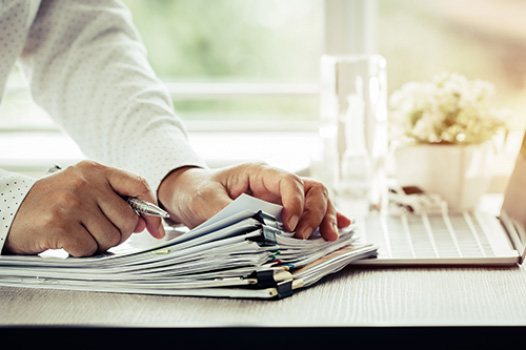 Man papers documents laptop desk work